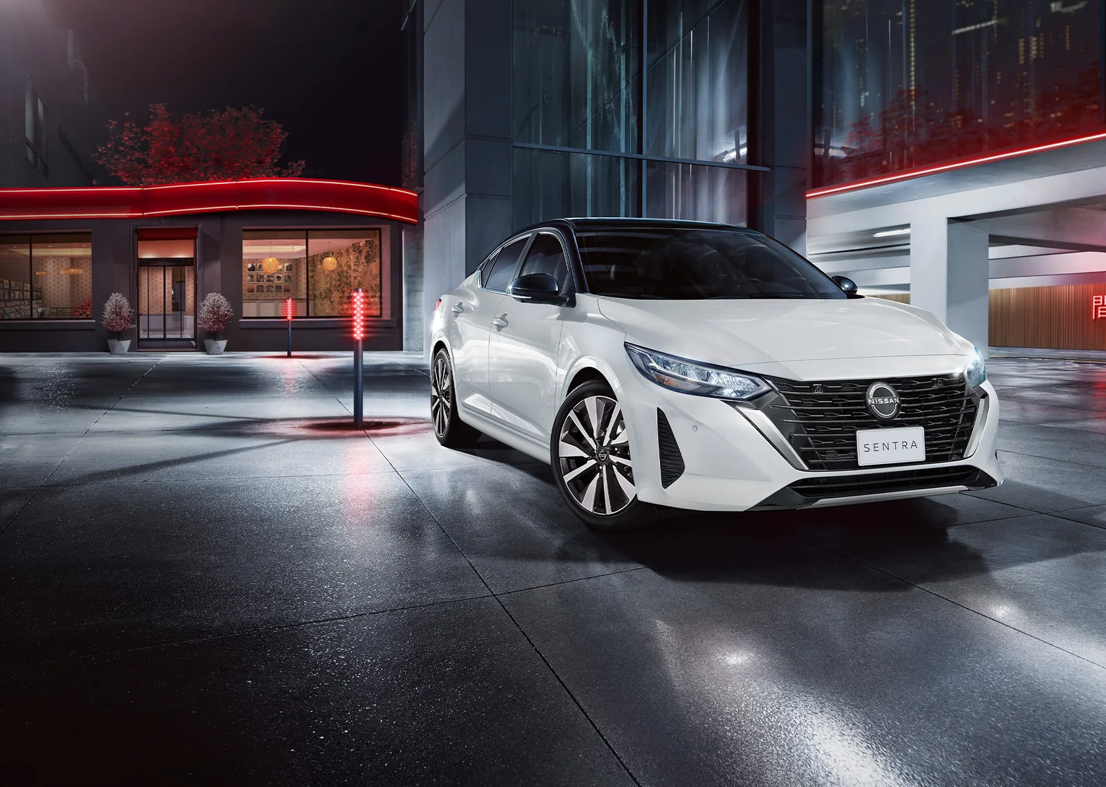 Nissan Sentra branco em cenário urbano noturno